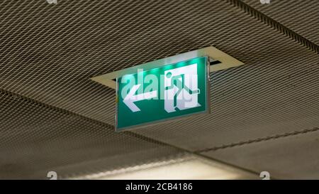 Panneau de sortie de secours éclairé. Signe vert avec une flèche blanche et un chiffre tournant vers la gauche. Symbole de fuite, fuite. Banque D'Images