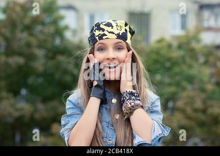 Jeune femme lumineuse en surprise touchant les joues et regardant heureusement à l'appareil photo Banque D'Images