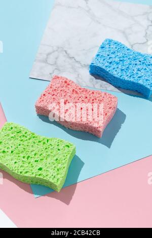 Disposition créative avec éponges pour le lavage de la vaisselle sur fond multicolore Banque D'Images