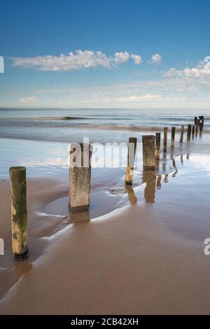 Groynes dans le sable et la mer à Burnham on Sea, Somerset Banque D'Images
