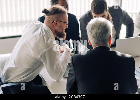 Caucasian businessman partage d'idées sur le projet multi-ethnique avec ses collègues de travail dans la salle de conférence, affectif, positif et concentré sur son discours de l'homme Banque D'Images