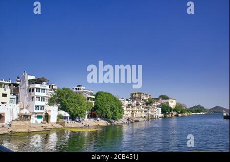 Maisons indiennes à côté d'un lac situé dans la ville d'Udaipur dans l'État du Rajasthan, Inde Banque D'Images