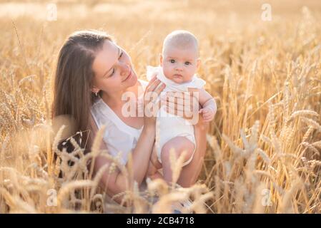 Belle jeune mère et sa petite fille au champ de blé par temps ensoleillé, république tchèque Banque D'Images