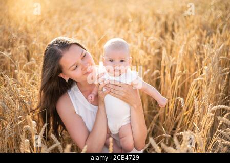 Belle jeune mère et sa petite fille au champ de blé par temps ensoleillé, république tchèque Banque D'Images