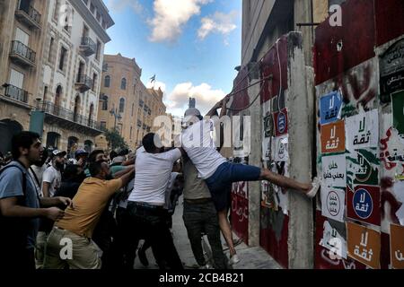 Beyrouth, Liban. 10 août 2020. Les militants anti-gouvernementaux tentent de mettre en place le bloc de béton qui ferme la route qui mène à la maison du Parlement lors d'affrontements avec la police anti-émeute dans le centre-ville de Beyrouth. Le gouvernement libanais a démissionné à la suite de l'explosion massive du port de Beyrouth, le 04 août, qui a tué au moins 158 personnes, blessé 6000 personnes et déplacé de 250,000 à 300,000 personnes. Credit: Marwan Naamani/dpa/Alamy Live News Banque D'Images