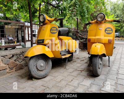 New Delhi, Inde, 2020. Les scooters Bajaj de couleur jaune fantaisie/quercy sont garés et utilisés pour la livraison de nourriture par le restaurant Fat Albert Banque D'Images