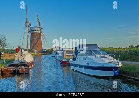 La pompe à vent de Norfolk Broads, avec une variété de bateaux amarrés dans la digue en soirée d'été Banque D'Images