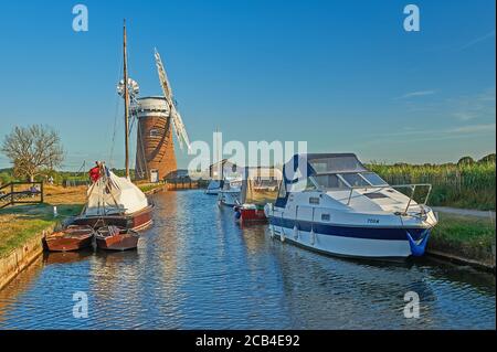 La pompe à vent de Norfolk Broads, avec une variété de bateaux amarrés dans la digue en soirée d'été Banque D'Images