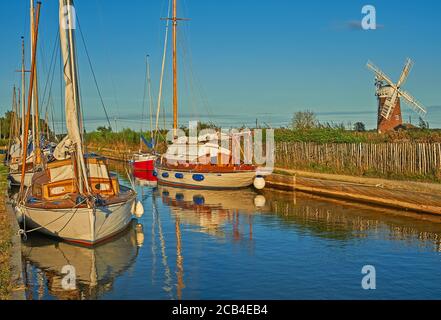 La pompe à vent de Norfolk Broads, avec une variété de bateaux amarrés dans la digue en soirée d'été Banque D'Images