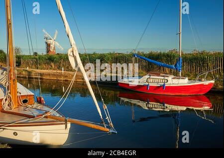 La pompe à vent Horsey Dyke et Horsey dans le parc national de Norfolk Broads un après-midi d'été, avec des bateaux amarrés le long de la digue Banque D'Images