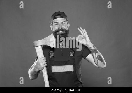 forester tenir la hache. l'homme en uniforme couper les cheveux de barbe avec la hache. l'homme barbu brutal utiliser la hache. Randonnée vacances. Assez courageux. Mieux utiliser la lame dans le barbershop. Brutal et barbu. L'homme montre un geste ok. Banque D'Images