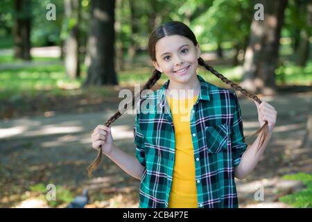 Fille scout mignon braides porter des vêtements à carreaux nature fond, concept de camping. Banque D'Images