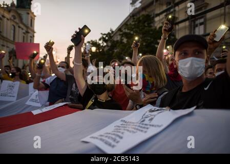 Les manifestants allument leurs smartphones comme un symbole de solidarité avec les manifestants en Biélorussie pendant la manifestation.les Biélorusses vivant en Pologne se sont réunis à Varsovie pour protester contre la fraude électorale dans leur pays et pour manifester leur solidarité avec les manifestants en Biélorussie. Selon les résultats officiels, le président biélorusse Alexandre Loukachenko a reçu plus de 80 pour cent des voix. Banque D'Images