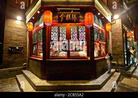 Pékin : un tout-petit chinois dans un magasin de bonbons de la région de Qianmen, la nuit. Chine Banque D'Images