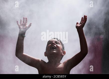 Paris, France. 10 août 2020. Un garçon se rafraîchit sous une fontaine à vapeur aux plages de Paris à Paris, France, le 10 août 2020. Credit: Gao Jing/Xinhua/Alamy Live News Banque D'Images