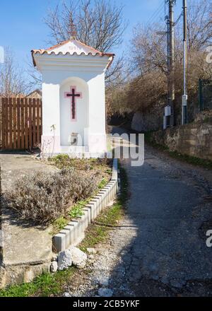 Petit sanctuaire blanc en bordure de voie, bénédiction routière ou torture de dieux avec passage à côté de la courbe de route du village à Srbsko, République tchèque Banque D'Images