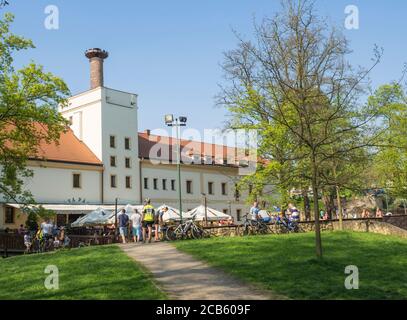 République Tchèque, Prague, Dolni Pocernice, 21 avril 2018: Ancienne brasserie restaurant Pansky dvur Dolni Pocernice avec groupe de personnes et de détente cycliste Banque D'Images