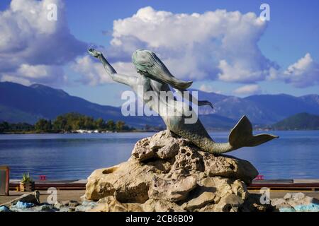 Statue de la Sirène et fontaine d'eau sur le front de mer de la ville de Poros, Grèce. Poros est une petite paire d'îles grecques dans la partie sud du golfe Saronique Banque D'Images