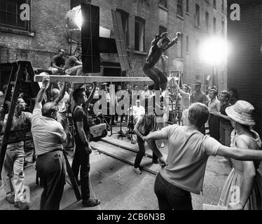 Directeur ROBERT WISE (assis au centre) Sur le set Candide dirigeant GEORGE CHAKIRIS dans numéro de danse sur Emplacement à New York pour LES réalisateurs DE WEST SIDE STORY 1961 JEROME ROBBINS et ROBERT WISE musique Leonard Bernstein paroles Stephen Sondheim A Robert Wise production / The Mirisch Corporation / Artistes Unis Banque D'Images