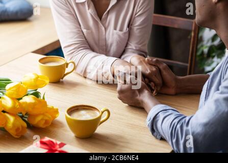 Vue rapprochée du couple noir millénaire qui tient les mains à café-restaurant Banque D'Images