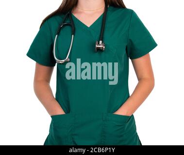 Jeune femme blanche médecin ou infirmière en vert se frotte avec un stéthoscope autour de son cou et les mains dans ses poches, isolé sur un fond blanc Banque D'Images