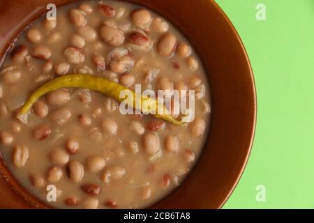 Vue de dessus de près d'un porridge de haricots recouvert de jaune cayenne dans un bol brun Banque D'Images