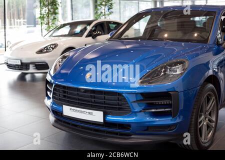 Russie, Izhevsk - 04 août 2020 : nouvelle voiture moderne de première classe Macan S dans la salle d'exposition Porsche. Vue avant et latérale. Célèbre marque mondiale. Banque D'Images