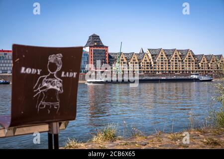 Vue sur le Rhin jusqu'à l'immeuble de bureaux Silo 23, un ancien grenier et à l'ancien entrepôt du port de Rheinau, graffiti sur une chaise, C Banque D'Images