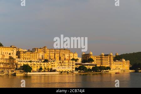 City Palace vu du lac Pichola lors d'une soirée lumineuse au crépuscule sous un ciel bleuté à Udaipur, Rajasthan, Inde. Banque D'Images