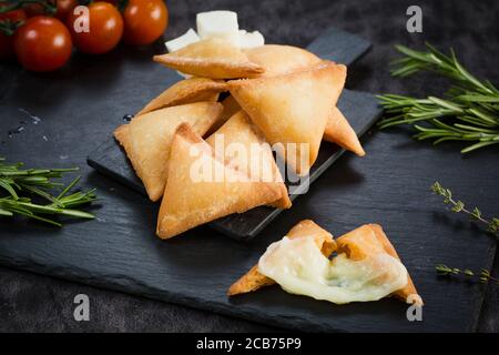 Fromage maison fraîchement cuit, pâtisseries savoureuses dans un cadre rustique. Samosa au fromage. Banque D'Images