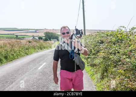 Garrylucas, Cork, Irlande. 11 août 2020. Lorcan Byrne de Skerries porte son Boston Terrier Woody sur une route de campagne tout en marchant sur une chaude après-midi à Garrylucas, Co. Cork, Irlande. - crédit; David Creedon / Alamy Live News Banque D'Images