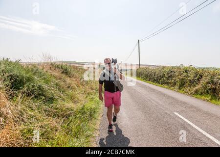 Garrylucas, Cork, Irlande. 11 août 2020. Lorcan Byrne de Skerries porte son Boston Terrier Woody sur une route de campagne tout en marchant sur une chaude après-midi à Garrylucas, Co. Cork, Irlande. - crédit; David Creedon / Alamy Live News Banque D'Images