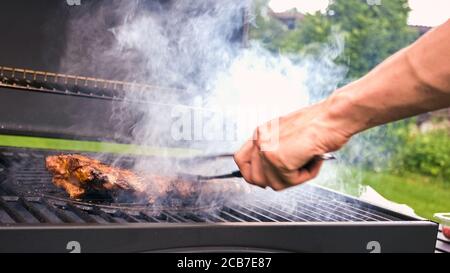 Barbecue à la maison avec charbon de bois dans l'arrière-cour pour griller des steaks et d'autres viandes pour le régime de carnivore. Banque D'Images