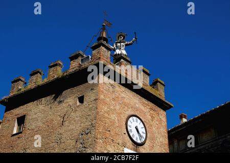 Dire l'heure à toute la ville. Une figure automatisée en bois, vêtue de costume de clown métallique, frappe les heures au sommet d'une tour, la Torre di Pulcinella (Tour de «Jr Punch»), sur la Piazza Michelozzo, Montepulciano, Toscane, Italie. Pulcinella était un personnage qui est apparu dans la commedia italienne dell’arte en 1600s. Banque D'Images