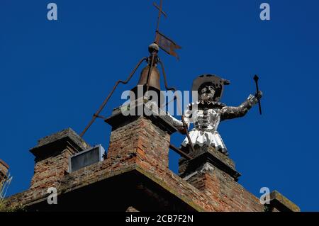 Dire l'heure à toute la ville. Une figure automatisée en bois, vêtue de costume de clown métallique, frappe les heures au sommet d'une tour, la Torre di Pulcinella (Tour de «Jr Punch»), sur la Piazza Michelozzo, Montepulciano, Toscane, Italie. Pulcinella était un personnage qui est apparu dans la commedia italienne dell’arte en 1600s. Banque D'Images