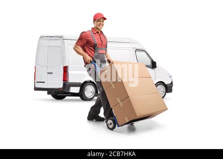 Homme travaillant dans un uniforme poussant un chariot à main chargé avec des caisses devant une camionnette blanche isolée sur arrière-plan blanc Banque D'Images