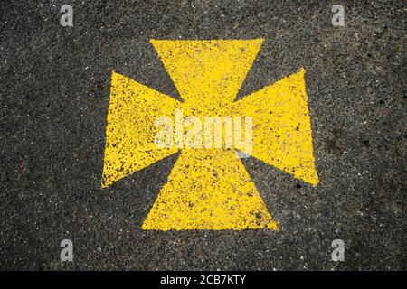 Croix maltaise jaune, aire de stationnement pour ambulance marquée du symbole jaune. Banque D'Images