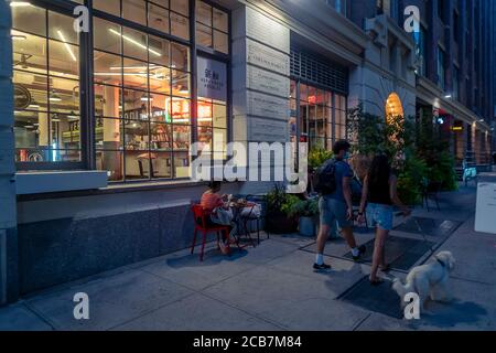 Dîner en plein air à l'extérieur du marché de Chelsea, dans le quartier de Chelsea, à New York, le samedi 8 août 2020. Bien que les repas en plein air soient désormais autorisés, les repas à l'intérieur dans le cadre de la réouverture de la phase 3 à New York City ont été reportés en raison de problèmes de non-conformité liés au coronavirus. (© Richard B. Levine) Banque D'Images