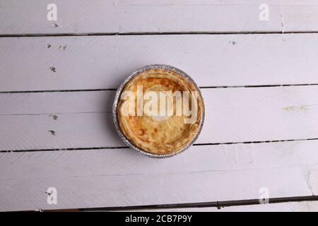 Plat d'une tarte aux œufs dans une feuille d'aluminium plateau isolé sur un fond rustique blanc Banque D'Images