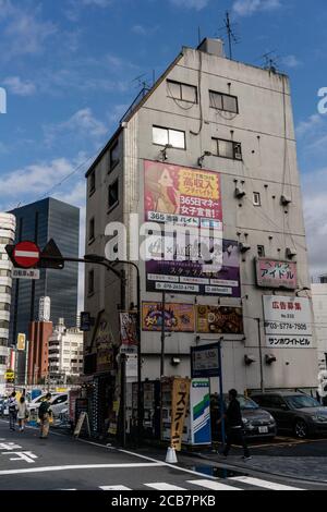 Japon, Tokyo, Ikebukuro 06 octobre 2019 Marche dans le quartier Ikebukuro, petit bâtiment avec des affiches publicitaires. Banque D'Images