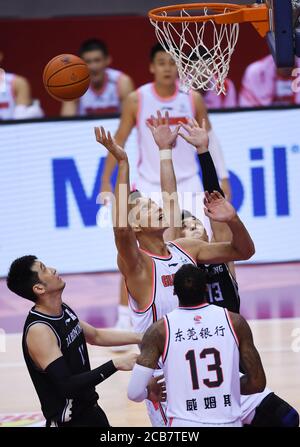 (200811) -- QINGDAO, le 11 août 2020 (Xinhua) -- Yi Jianlian (C) de Guangdong Southern Tigers rivalise lors du premier match de la finale entre Guangdong Southern Tigers et Liaoning Flying Leopards à la ligue 2019-2020 de l'Association chinoise de basket-ball (CBA) à Qingdao, dans la province de Shandong en Chine orientale, le 11 août 2020. (Xinhua/Li Ziheng) Banque D'Images