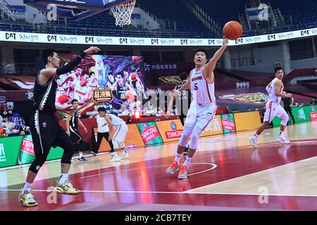 (200811) -- QINGDAO, 11 août 2020 (Xinhua) -- Wang Xinkai (2e R) de Guangdong Southern Tigers rivalise pour le ballon lors du premier match de la finale entre Guangdong Southern Tigers et Liaoning Flying Leopards à la ligue 2019-2020 de l'Association chinoise de basket-ball (CBA) à Qingdao, province de Shandong en Chine orientale, le 11 août 2020. (Xinhua/Zhu Zheng) Banque D'Images