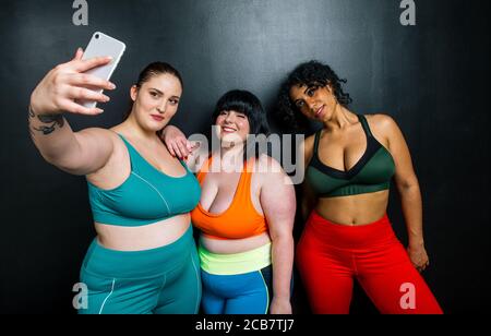 Les femmes de taille plus font du sport et de la forme physique. Portraits de studio avec des filles multiethniques aux courbes Banque D'Images