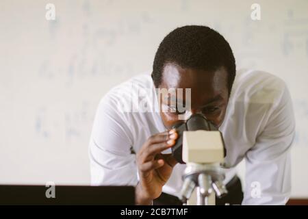 Professeur scientifique africain de microscopes à la recherche dans le laboratoire Banque D'Images