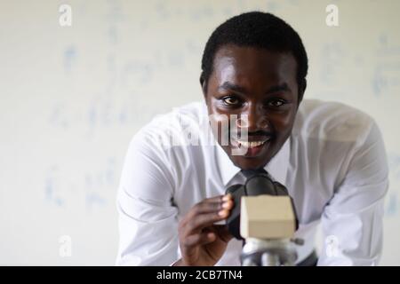 Professeur scientifique africain de microscopes à la recherche dans le laboratoire Banque D'Images