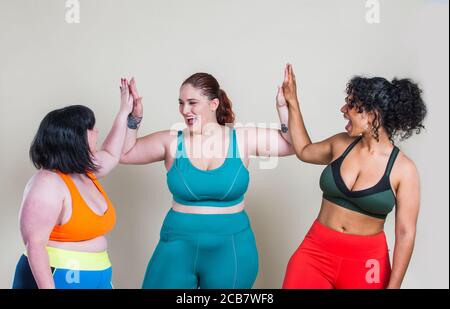 Les femmes de taille plus font du sport et de la forme physique. Portraits de studio avec des filles multiethniques aux courbes Banque D'Images