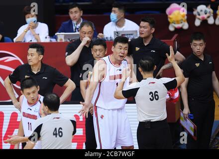 (200811) -- QINGDAO, 11 août 2020 (Xinhua) -- Su Wei (C) de Guangdong Southern Tigers s'entretient avec l'arbitre Yan Jun après avoir été fouillé lors du premier match de la finale entre Guangdong Southern Tigers et Liaoning Flying Leopards à la ligue de l'Association chinoise de basket-ball (CBA) 2019-2020 à Qingdao, dans la province de Shandong en Chine orientale, le 11 août 2020. (Xinhua/Li Ziheng) Banque D'Images