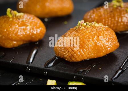 Pâtisserie arabe douce. Baklava turque traditionnelle. Bonbons arabes syriens turcs à la pistache sur fond sombre. Banque D'Images