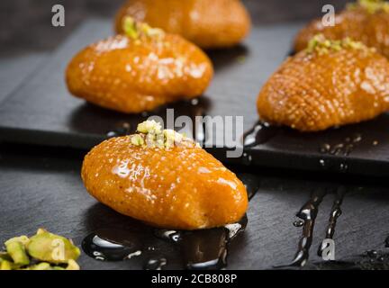 Pâtisserie arabe douce. Baklava turque traditionnelle. Bonbons arabes syriens turcs à la pistache sur fond sombre. Banque D'Images