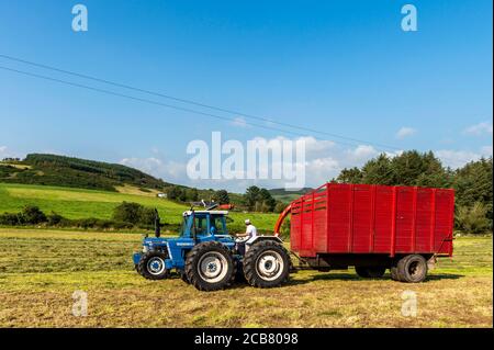 LEAP, West Cork, Irlande. 11 juillet 2020. Lors d'une journée ensoleillée, les membres du Leap and District Vintage Club collectent de l'ensilage pour le cultivateur de Leap Andrew Whelton à l'aide de tracteurs et de moissonneuses d'époque. Sur la photo, Ryan Jennings et Declan O'Donovan conduisent respectivement un Ford 7810 1990 série 3 et un County 1004 1968. La récolteuse est une Mengele MSH22 des années 1990. Crédit : AG News/Alay Live News Banque D'Images